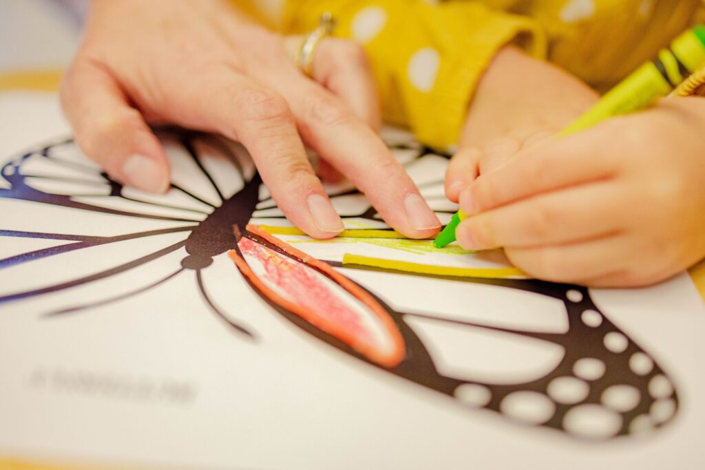 And adult and child coloring in a butterfly image