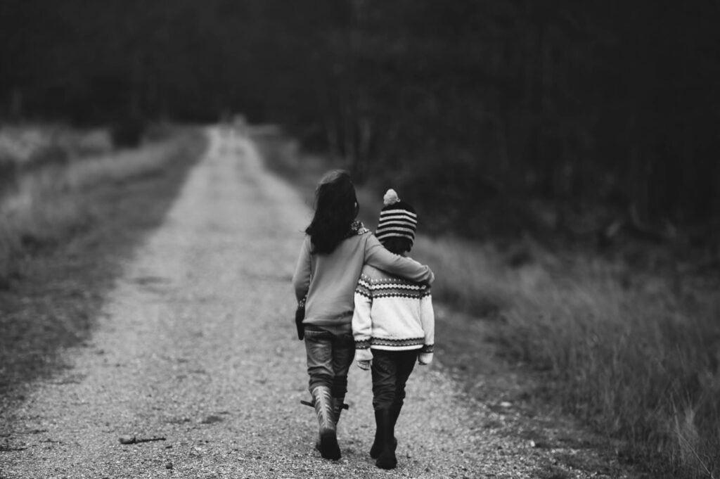 Two children walking away down a path